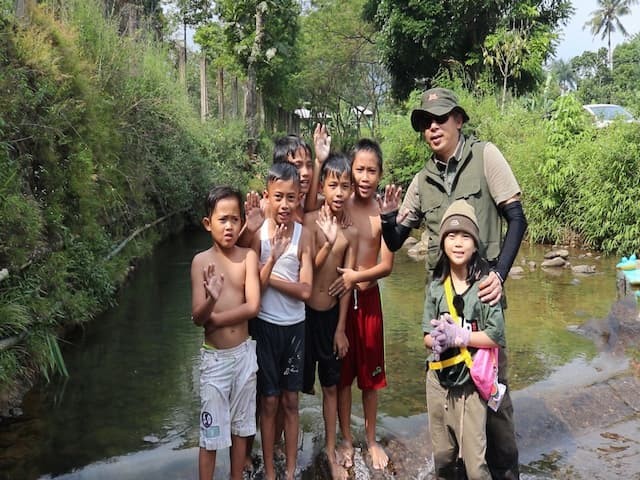 ola dan anak-anak berfoto di aliran sungai